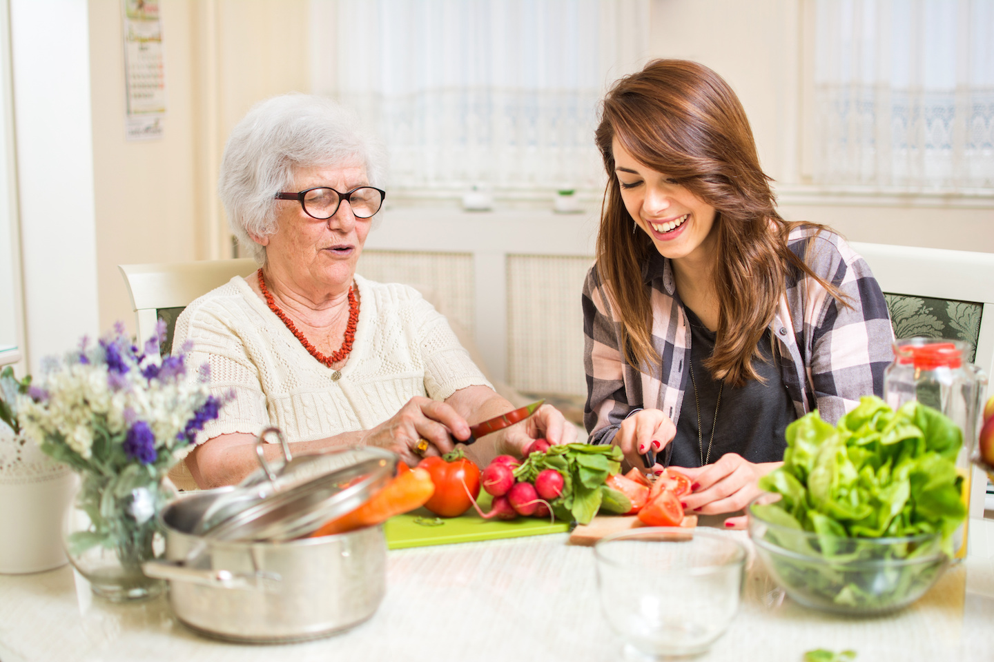 Grandmother and granddaughter preparing food at home.