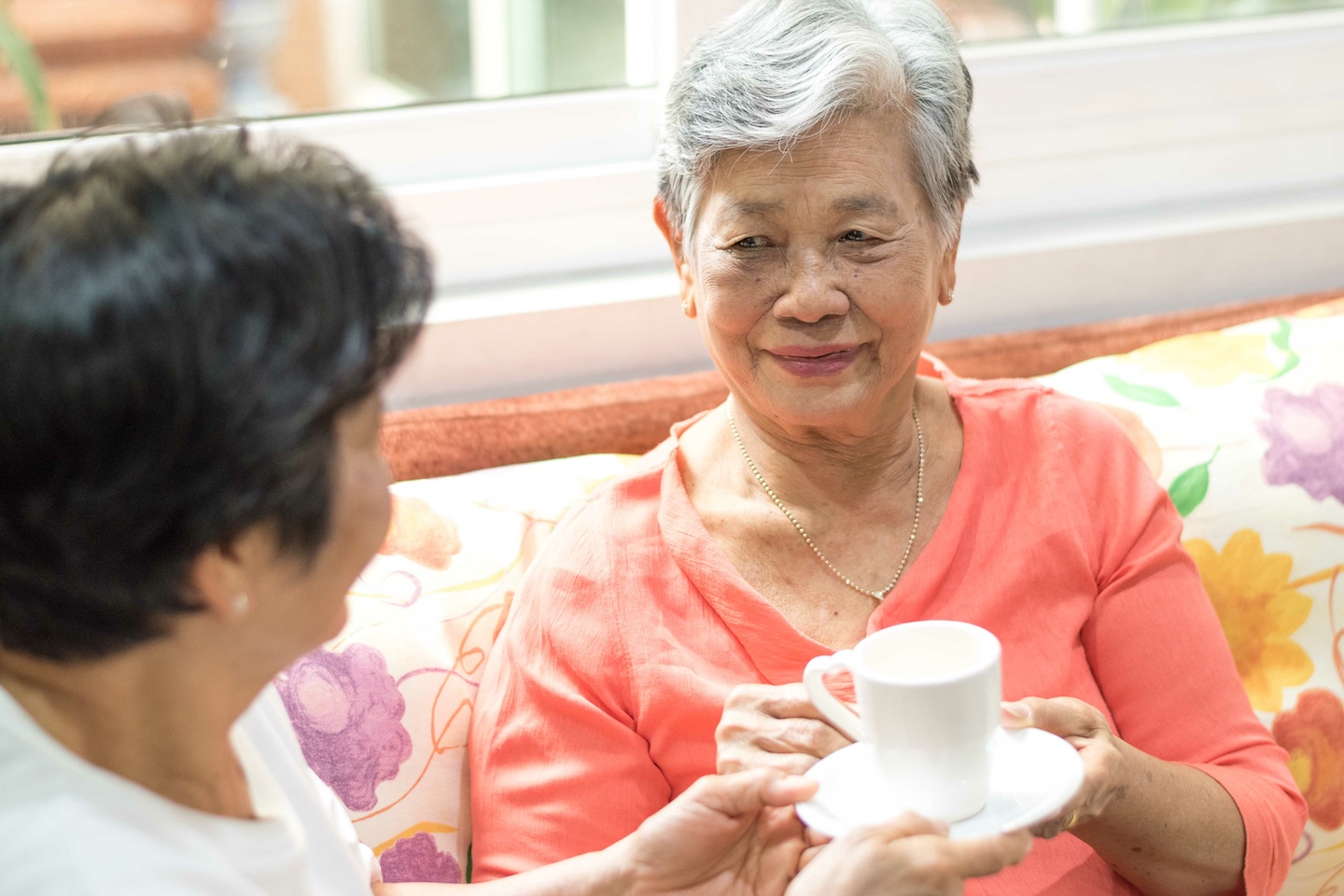 Happy senior freindship society concept. Portrait of Asian female older ageing women smiling with happiness serving hot tea taking care each other at home,nursing home, or wellbeing county